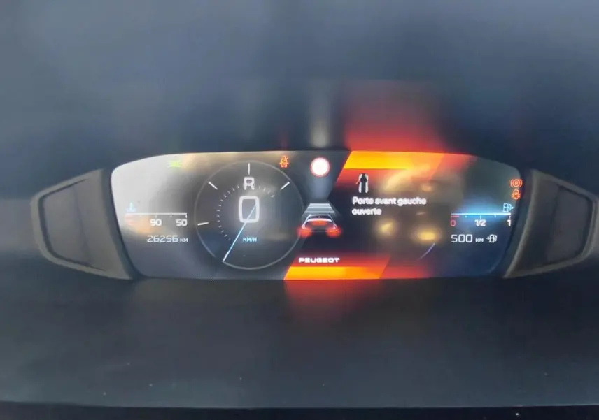 Affichage numérique du cockpit de la Peugeot 308 gris, indiquant porte avant gauche ouverte et vitesse à 0 km/h.