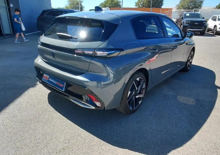 PEUGEOT 308 gris vue 3/4 arrière droit, avec feux arrière LED et jantes alliage distinctives.
