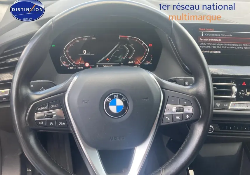 Vue rapprochée du volant cuir noir multifonction et tableau de bord numérique de la BMW Série 1 118i 2023.