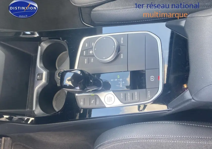 Vue rapprochée de la console centrale noire brillante de la BMW Série 1 118i 2023 avec levier de vitesse automatique et commandes.