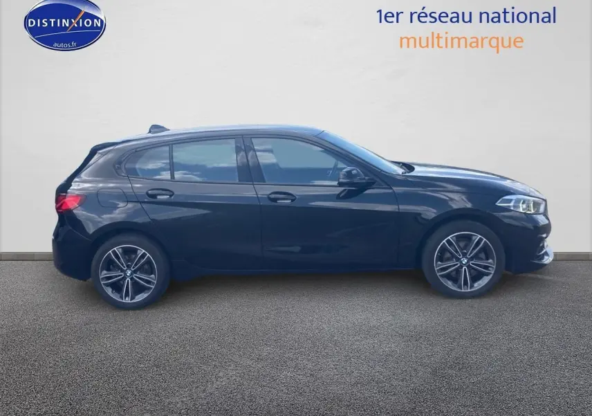 Profil côté gauche d'une BMW Série 1 noire édition sport 2023 avec jantes alliage et vitres teintées.