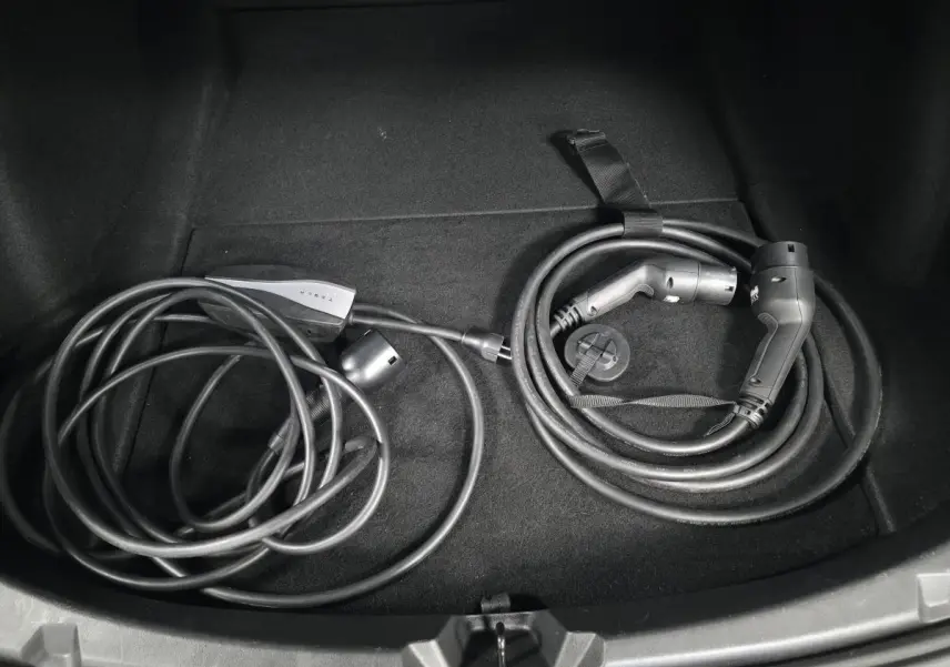 Câbles de recharge électrique rangés dans le coffre d'une Tesla Model 3 RWD bleu foncé 2021.
