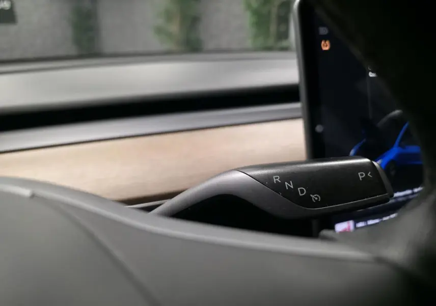 Le levier de boîte automatique noir de la Tesla Model 3 2021 RWD, vu en gros plan côté droit du volant.