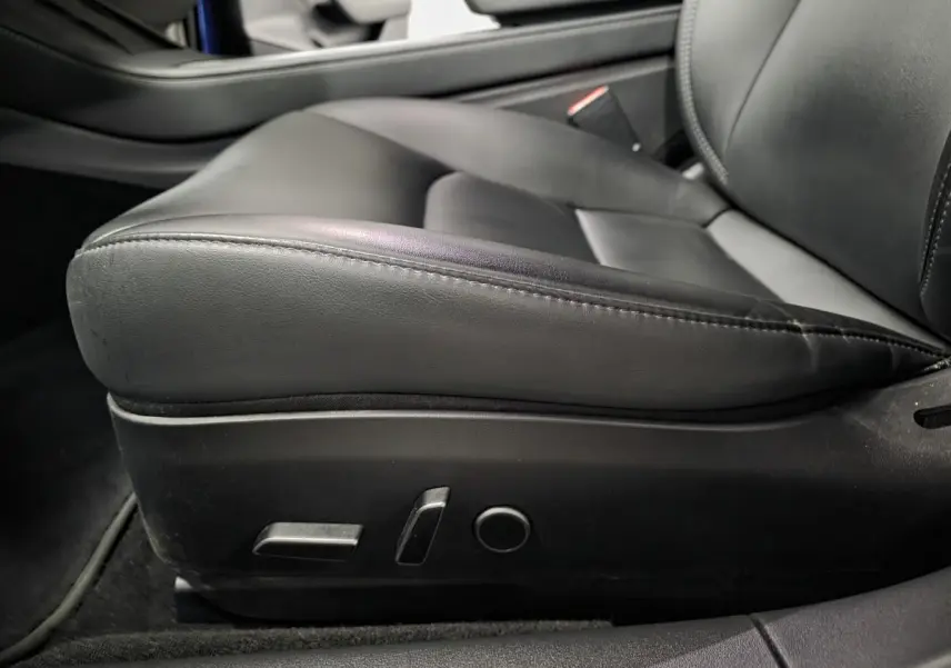 Gros plan sur le siège conducteur en cuir noir avec commandes électriques de la Tesla Model 3 RWD 2021.