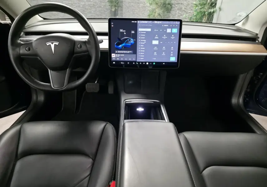 Intérieur noir de la Tesla Model 3 RWD 2021 avec tableau de bord minimaliste et grand écran tactile central.