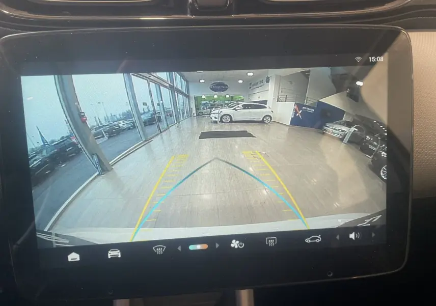 Écran tactile intérieur montrant la caméra de recul d'une LEAPMOTOR T03 Luxury blanche en showroom.