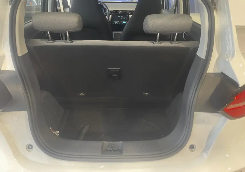 Vue arrière du coffre ouvert d'un LEAPMOTOR T03 Luxury blanc, montrant l'intérieur noir et les appuie-têtes arrière.