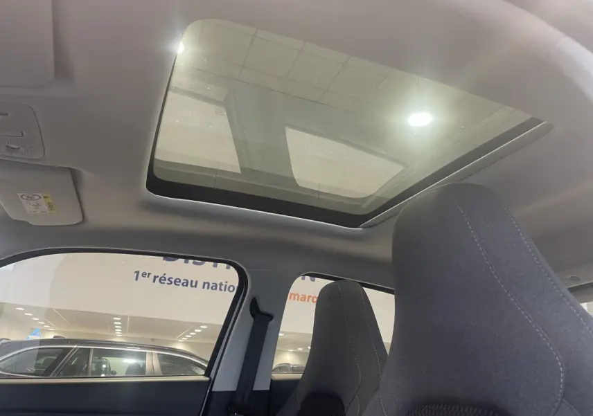 Vue intérieure du toit ouvrant panoramique et des sièges avant en tissu gris du LEAPMOTOR T03 Luxury blanc.