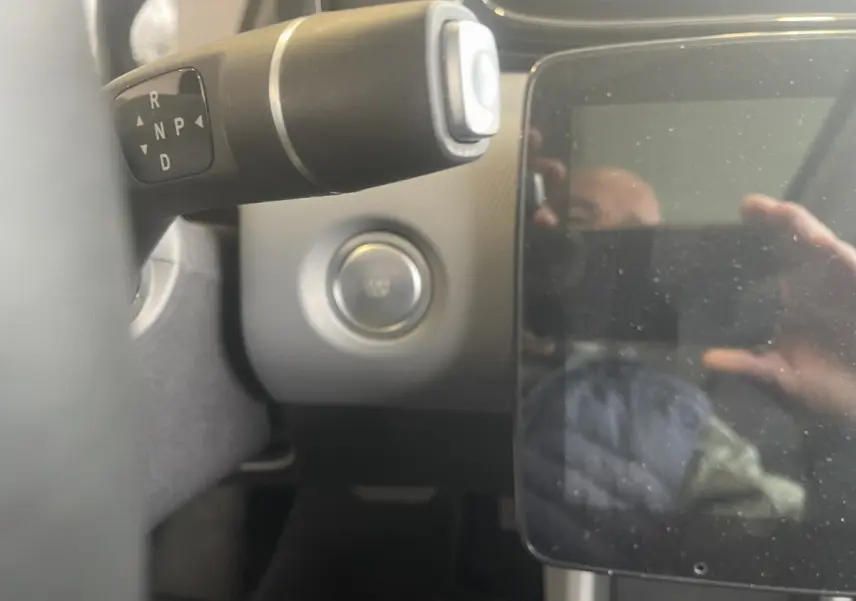 Gros plan sur le bouton de démarrage et levier de boîte auto noir dans l’habitacle du Leapmotor T03 Luxury blanc.