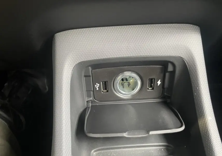 Gros plan sur la prise 12V et ports USB intégrés dans la console centrale du Leapmotor T03 Luxury blanc.