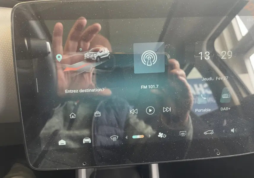 Écran tactile central du tableau de bord du Leapmotor T03 Luxury blanc, affichant la navigation et la radio FM.