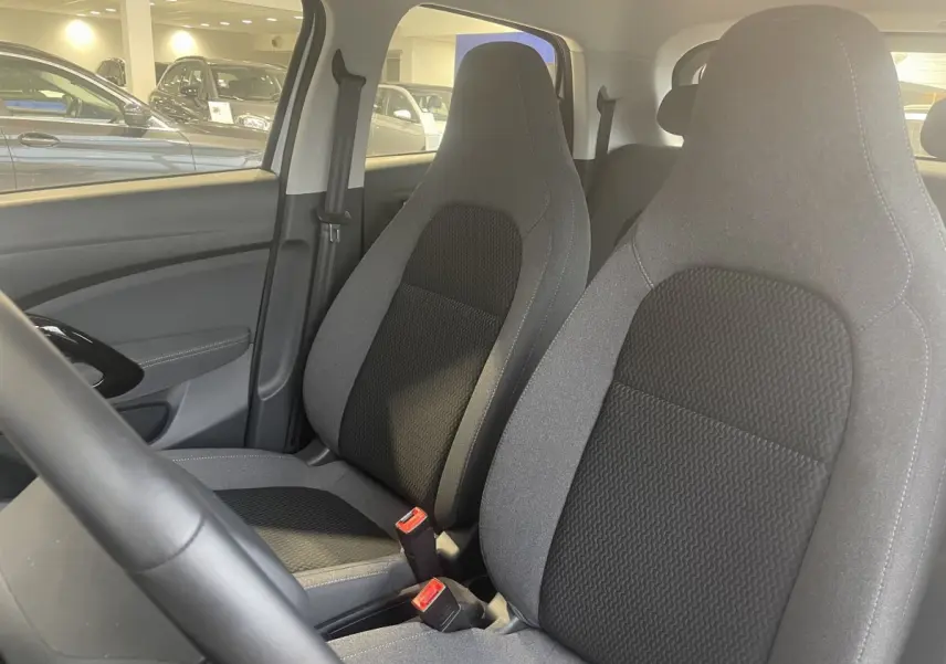 Vue intérieure rapprochée des sièges avant gris et noirs du LEAPMOTOR T03 Luxury 2025, avec volant partiel visible.