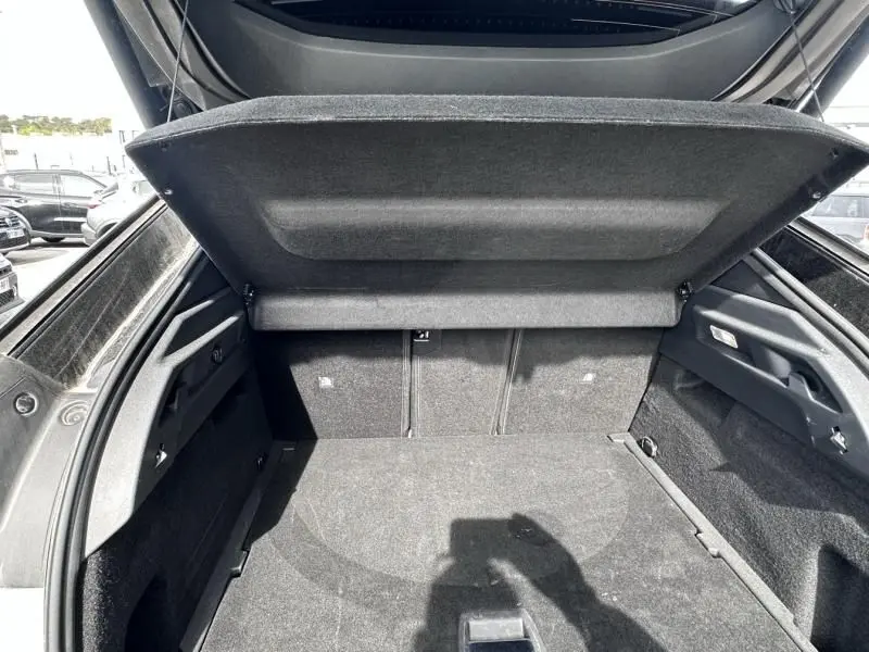 Coffre ouvert du Peugeot 3008 Nouveau gris métal, vue arrière montrant l'espace de chargement et la tablette cache-bagages.