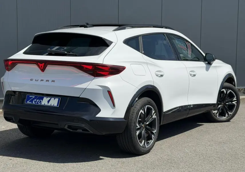 Vue 3/4 arrière droite d’un CUPRA Formentor blanc Neige avec jantes alliage noires et signature lumineuse Tri-LED.