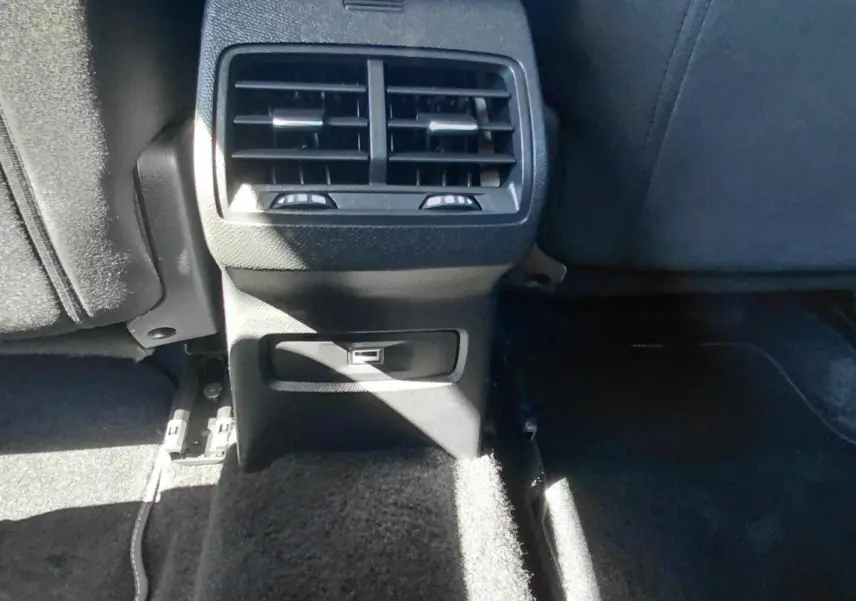 Vue rapprochée de la console arrière noire du Citroën C4 X 2025 avec bouches d’aération et prise USB.