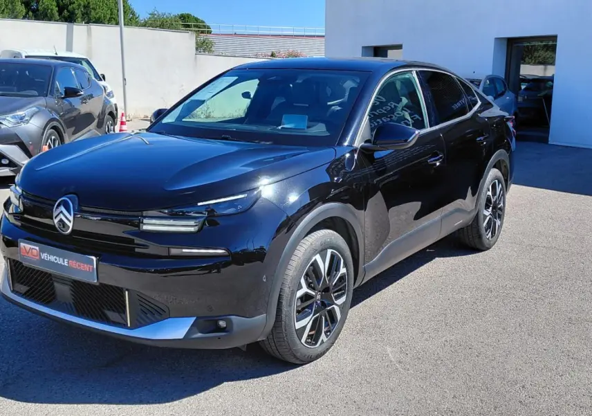 Vue 3/4 avant droite d'une Citroën C4 X noire 2025 avec jantes alliage 17 pouces et toit ouvrant panoramique.