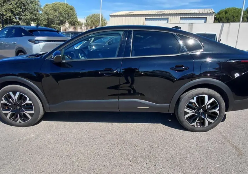 Profil côté gauche de la Citroën C4 X noire 2025 avec jantes alliage 17 pouces, toit ouvrant panoramique visible.