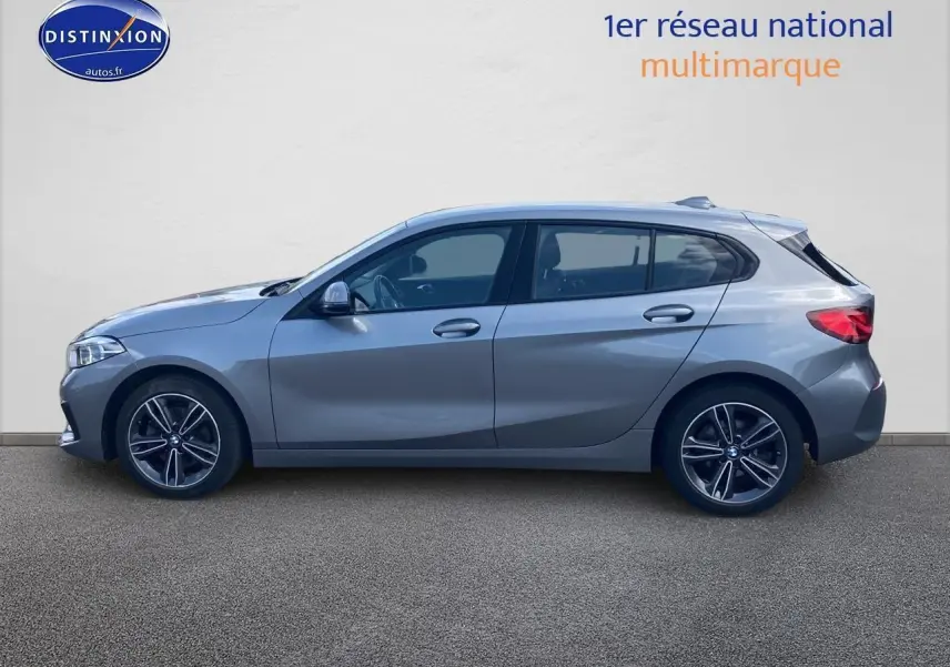 BMW Série 1 gris foncé vue de profil côté gauche avec jantes alliage 17 pouces et lignes sportives élégantes.
