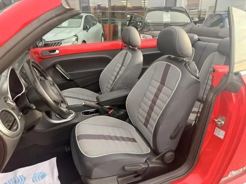 Intérieur de la Volkswagen Coccinelle Cabriolet rouge 2016, vue côté gauche sur les sièges en tissu denim avec surpiqûres rouges.