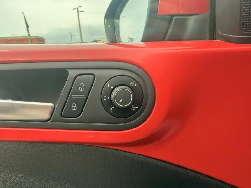 Détail de la commande des rétroviseurs sur la porte côté gauche d’une Volkswagen Coccinelle Cabriolet rouge 2016.