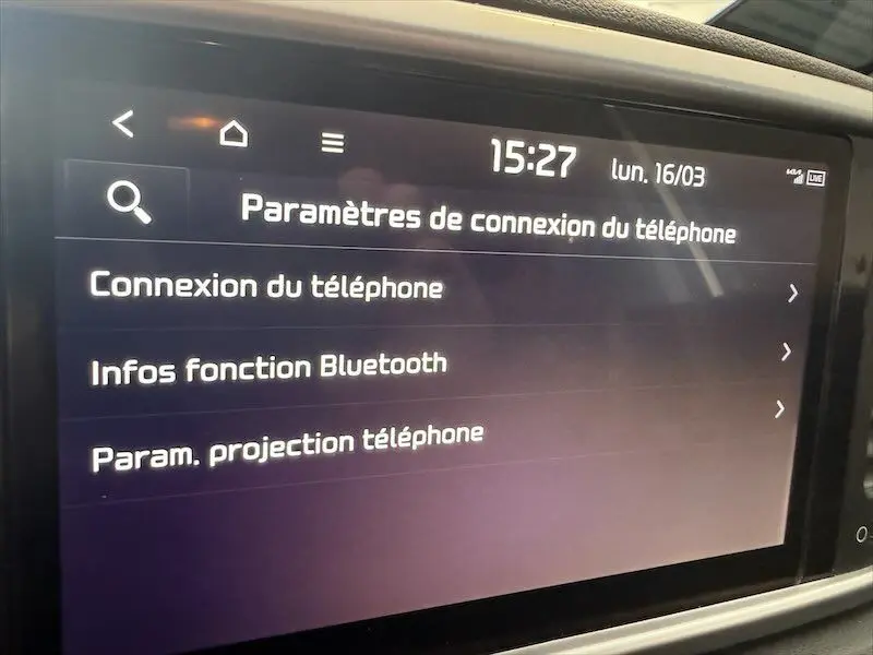 Écran tactile intérieur du Kia Sportage blanc 2021 affichant les paramètres de connexion Bluetooth au téléphone.