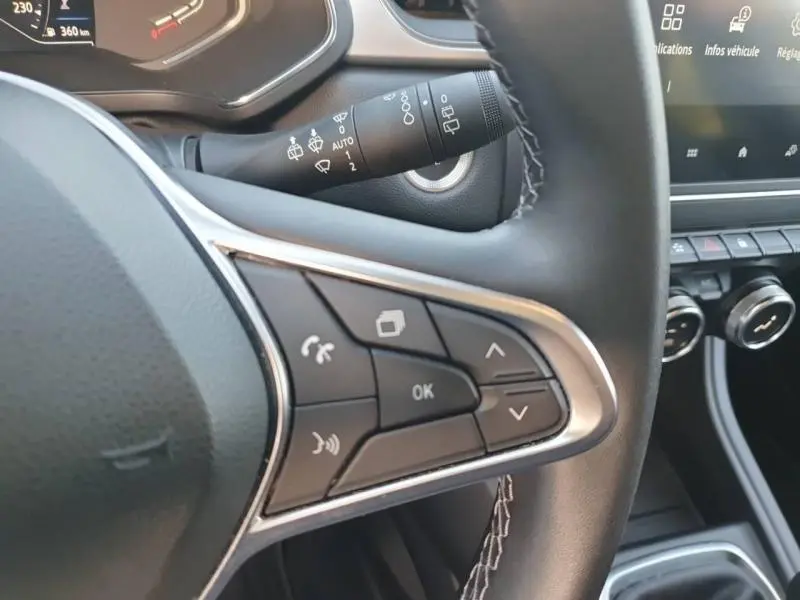 Gros plan sur les commandes multifonctions côté gauche du volant noir du Renault Captur 1.3 TCe 2023.