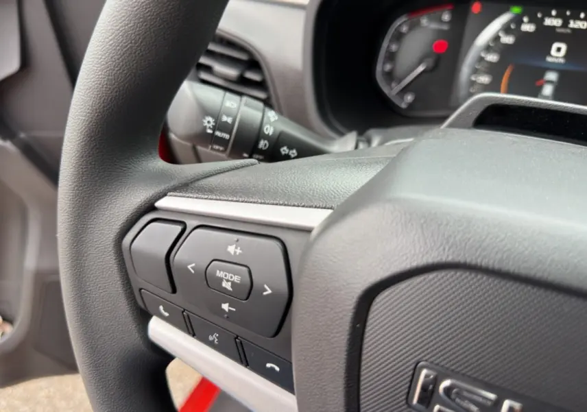 Gros plan sur le volant multifonctions noir de l'Isuzu D-MAX 2026 avec commandes audio et téléphone intégrées.