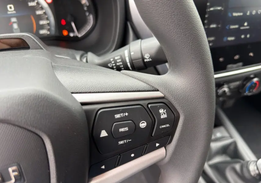 Gros plan sur le volant multifonctions noir de l'Isuzu D-MAX 2026 avec commandes de régulateur de vitesse.
