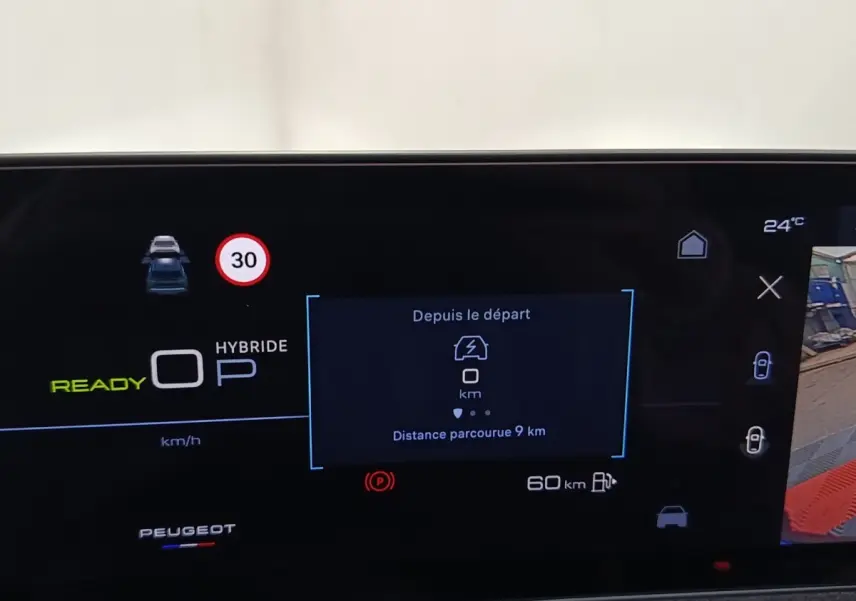 Affichage numérique du tableau de bord Peugeot 5008 hybride rechargeable montrant la vitesse, autonomie et aide au stationnement.