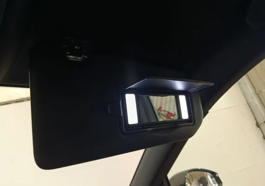 Miroir de courtoisie éclairé sur pare-soleil côté conducteur dans l’habitacle du Peugeot 5008 gris clair.