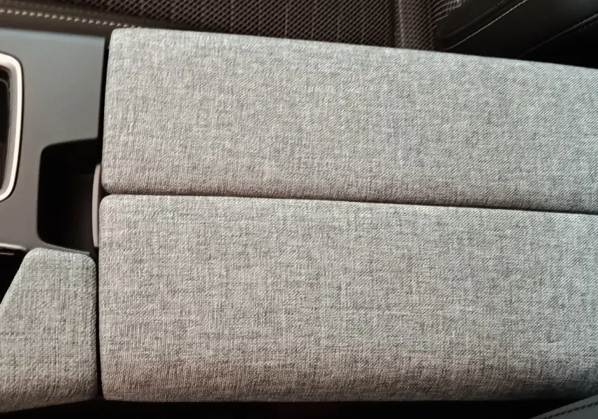 Détail de l’accoudoir central en tissu gris clair à l’intérieur du Peugeot 5008 1.6 PHEV 195 E-DCS7 GT 2026.