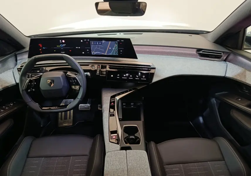 Vue intérieure avant du Peugeot 5008 1.6 PHEV gris clair, avec tableau de bord numérique et volant multifonctions cuir.