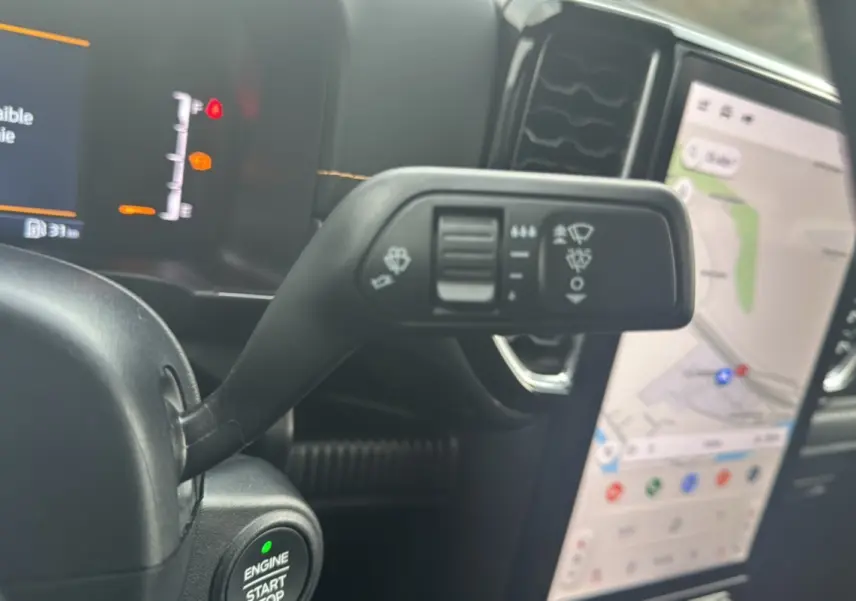 Gros plan sur la commande d’essuie-glace et le bouton start du Ford Ranger Wildtrak 2026, intérieur noir avec écran GPS.
