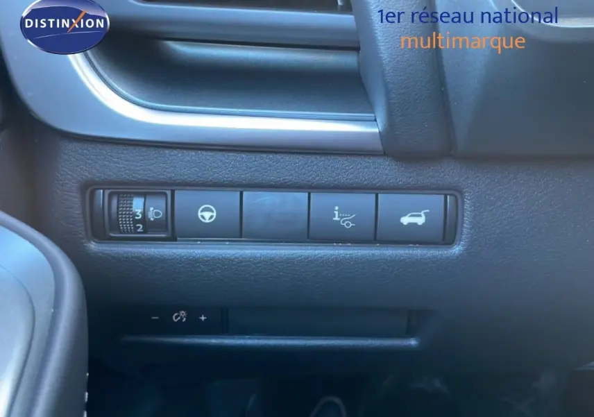 Gros plan sur les commandes noires du tableau de bord du Nissan Qashqai gris argile, côté conducteur.