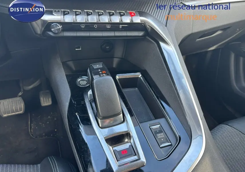 Vue rapprochée de la console centrale noire et chrome du Peugeot 3008 gris platinium, avec levier de vitesse et commandes visibles.