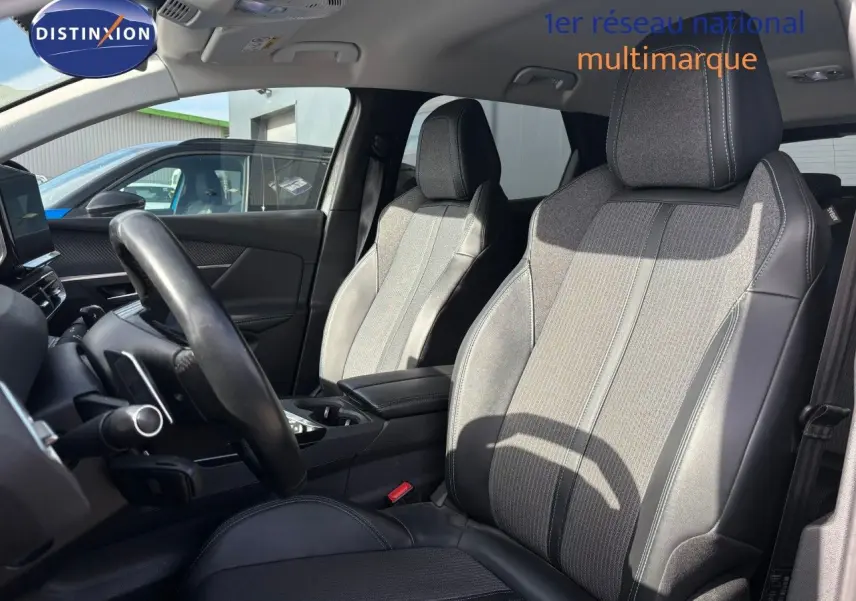 Vue intérieure côté conducteur du Peugeot 3008 hybride 2022, sièges en tissu et cuir noir avec surpiqûres grises.