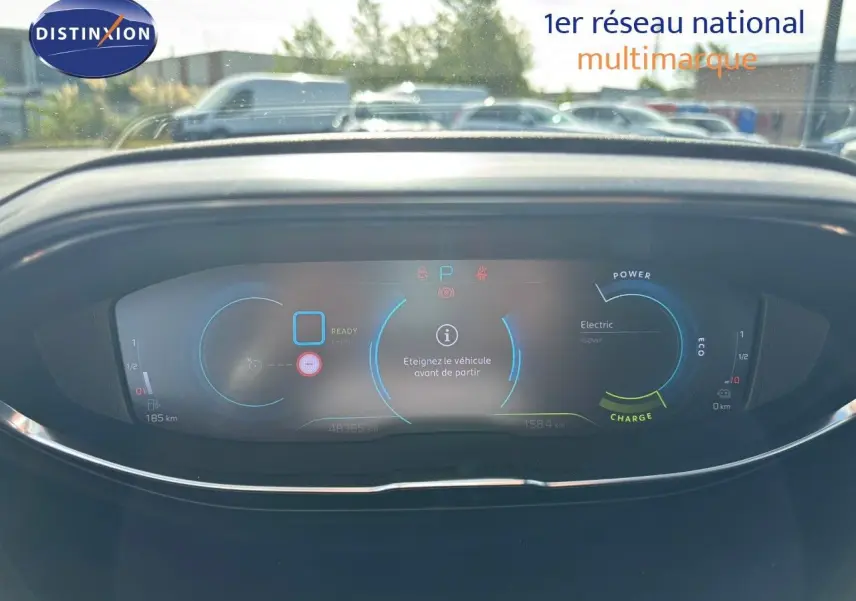 Vue rapprochée du tableau de bord numérique du Peugeot 3008 hybride gris platinium, affichant les indicateurs de charge et autonomie.