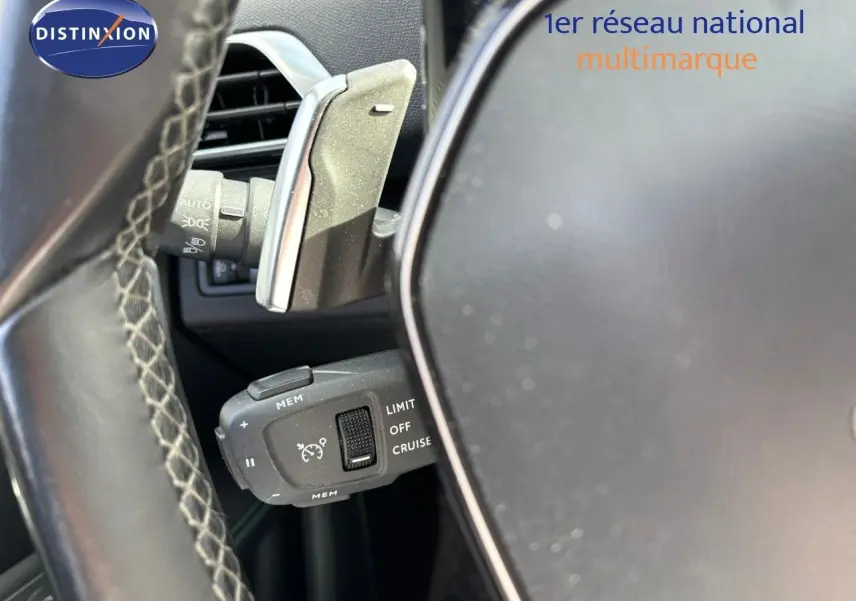 Gros plan sur la commande de régulateur de vitesse au volant cuir du Peugeot 3008 gris platinium 2022.