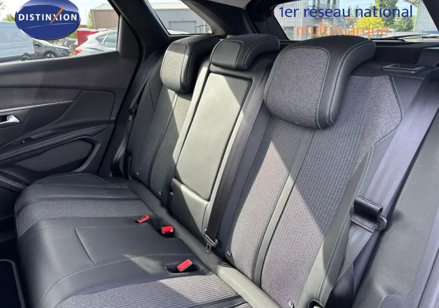 Vue intérieure des sièges arrière du Peugeot 3008 hybride 2022, tissu et cuir noir avec surpiqûres contrastantes.