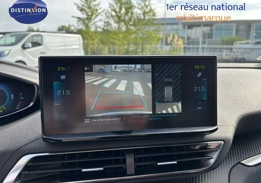 Vue intérieure du tableau de bord du Peugeot 3008 hybride 2022, écran central affichant la caméra de recul et la climatisation.