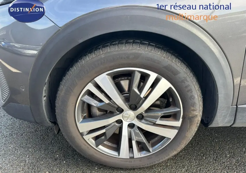 Gros plan sur la roue avant droite d’un Peugeot 3008 gris platinium métal avec jante alliage biton.
