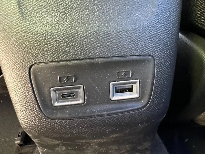 Prise USB-C et USB-A en gros plan sur console arrière d’un Peugeot 2008 bleu hybride 2025.