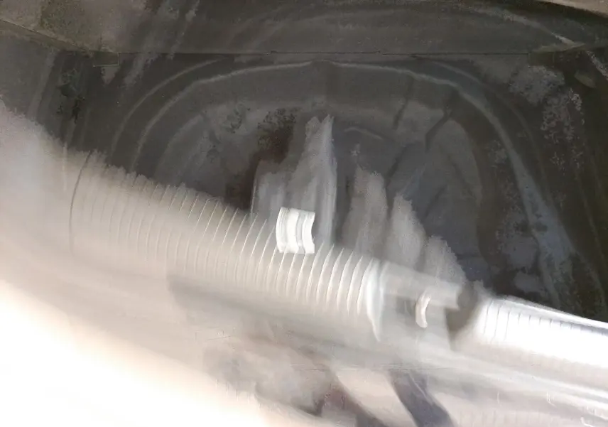 Vue intérieure floue du coffre d'une Volkswagen Golf 1.5 eTSI 150 DSG7 R Line noir intense nacré sans objet visible.