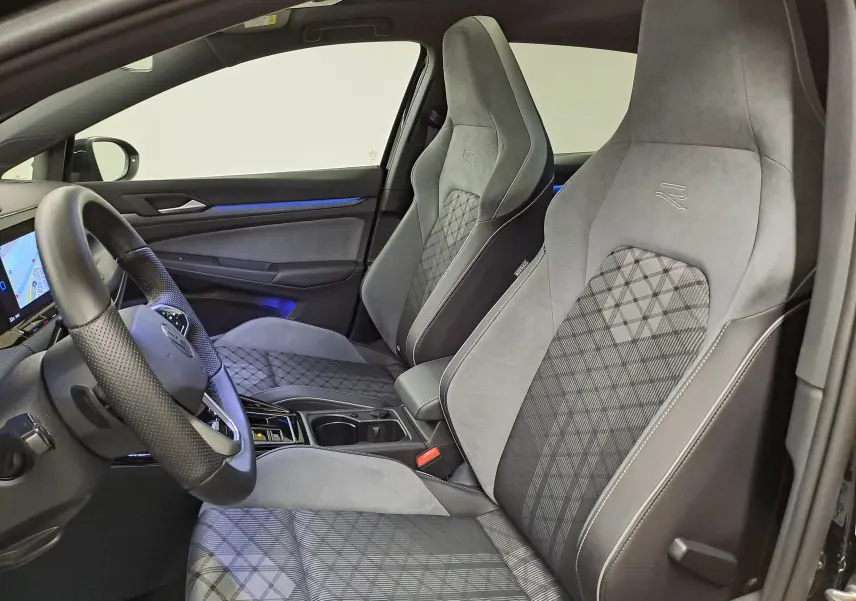 Vue intérieure côté gauche de la Volkswagen Golf 1.5 eTSI R Line 2023 avec sièges sport gris et volant cuir noir.