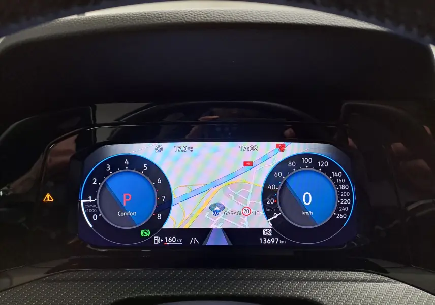 Vue rapprochée du combiné d'instruments digital de la Volkswagen Golf 1.5 eTSI 150 DSG7 R Line affichant la navigation et les compteurs numériques.