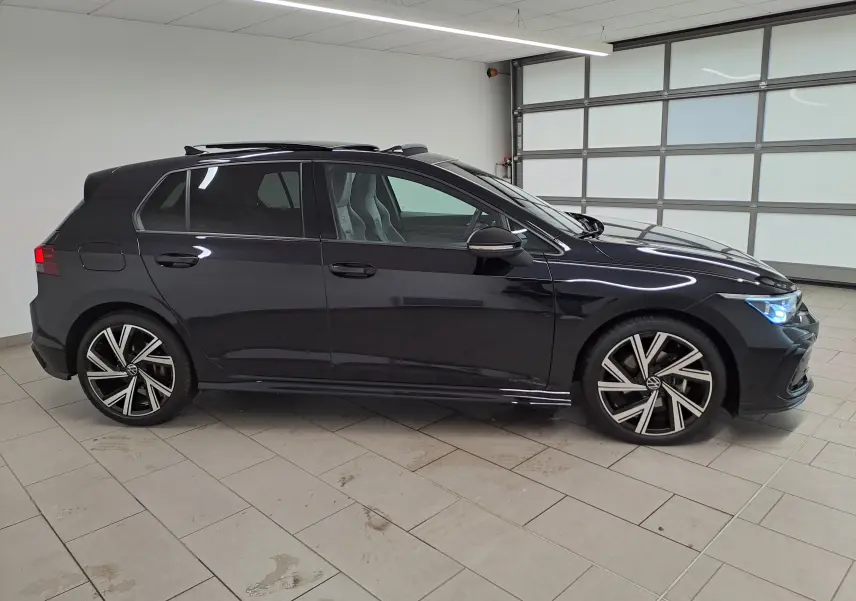 Vue de profil côté gauche d'une Volkswagen Golf 1.5 eTSI R Line noire nacrée avec toit ouvrant et jantes alliage distinctives.