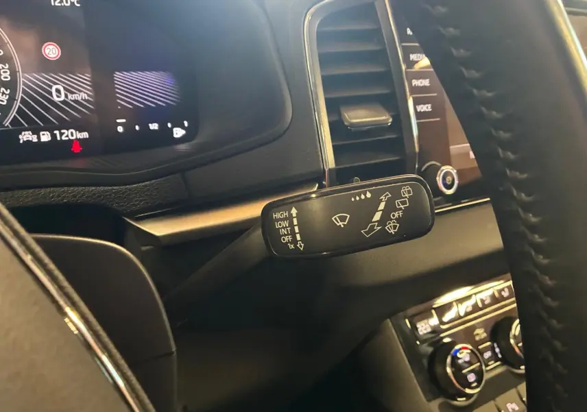 Gros plan sur la commande des essuie-glaces à gauche du volant dans l'habitacle noir du Skoda Karoq 2023.