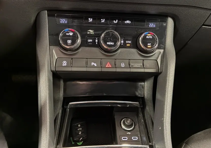 Vue rapprochée du tableau de bord central d'une Skoda Karoq 2023, montrant la climatisation automatique et les ports USB-C.