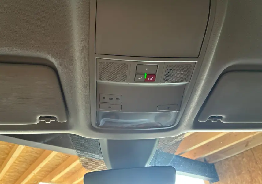 Vue intérieure du plafonnier gris avec commandes d'éclairage et bouton SOS du Skoda Karoq 2023 bleu.