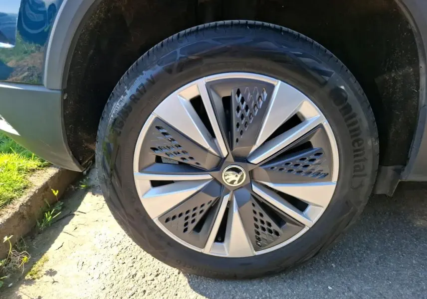 Gros plan sur la jante alu 17'' et le pneu Continental du côté avant droit d'un Skoda Karoq bleu.